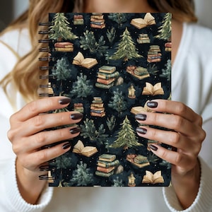 Può includere: Un taccuino a spirale con un motivo di libri impilati, libri aperti, pini e lanterne su sfondo blu scuro. Il design ha un effetto acquerello, con un'estetica vintage.