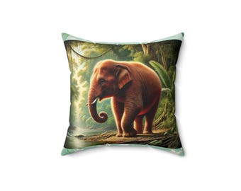 May include: Square throw pillow featuring a detailed illustration of a brown elephant in a lush jungle setting. The elephant stands near a river, surrounded by green foliage and trees. The pillow has a light green border.