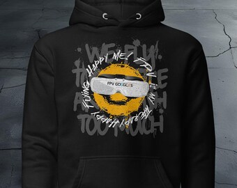 May include: Black hoodie with a graphic design featuring a yellow smiley face wearing white FPV goggles. The design includes the text "WE FLY. HAPPY ME? RV IS MY THERAPY. FLYING TOO MUCH."