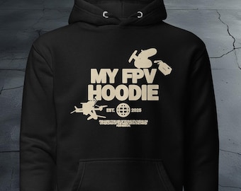 Puede incluir: Sudadera negra con un diseño gráfico blanco que presenta un dron y el texto "My FPV Hoodie" con las palabras "EST. 2025" debajo.