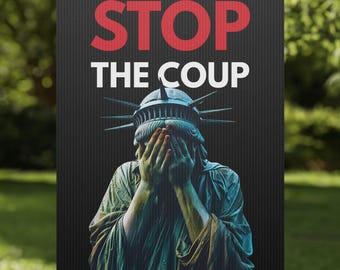 Puede incluir: Un letrero de jardín con las palabras "STOP THE COUP" en rojo y blanco. El letrero presenta una imagen de la Estatua de la Libertad con las manos cubriendo su rostro. El letrero está en un marco de metal en un jardín cubierto de hierba.