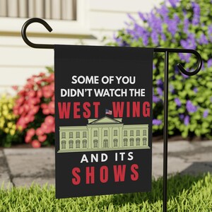 以下が含まれることがあります： 「SOME OF YOU DIDN'T WATCH THE WEST WING AND ITS SHOWS」の白と赤の文字が入った黒いガーデンフラッグ。ホワイトハウスのイラストとアメリカ国旗が描かれています。