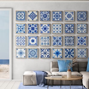 May include: A living room showcases a wall decorated with framed blue and white patterned tiles. A beige sectional sofa with blue cushions is positioned below the artwork. A round wooden coffee table and a blue rug complete the scene, with a sea view.