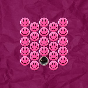 May include: A pink background with a grid of pink smiley face buttons. One button is missing from the center of the grid.
