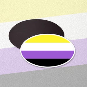 May include: A yellow, white, purple, and black striped oval sticker on a multi-colored background.