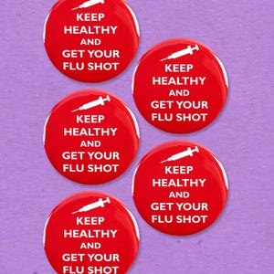Könnte beinhalten: Fünf rote runde Knöpfe mit weißem Text "KEEP HEALTHY AND GET YOUR FLU SHOT". Jeder Knopf hat eine weiße Spritzengrafik. Der Hintergrund ist eine einfarbige lila Farbe.