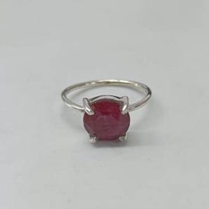 Puede incluir: Un anillo de plata con una piedra preciosa redonda roja grande.