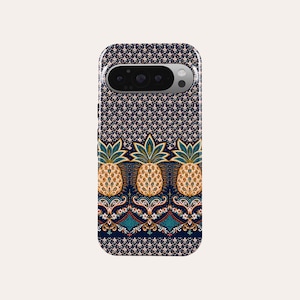May include: A phone case with a navy blue background and a repeating pattern of small pink flowers. The bottom of the case features three detailed pineapple illustrations with gold, green, and orange colours. The case has a camera cutout.