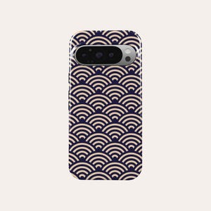 May include: A smartphone case featuring a navy blue and cream-colored wave pattern. The design is a repeating pattern of semi-circles, creating a textured appearance. The case has a camera cutout at the top.