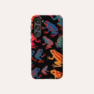May include: Black phone case featuring a colourful pattern of frogs. The frogs are red, blue, yellow and green. The phone case has a camera cutout.