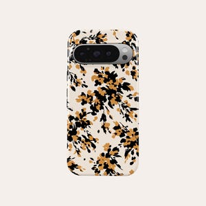 Op de afbeelding: Een telefoonhoesje met een bloemenpatroon. De hoes heeft een crèmekleurige achtergrond met een herhalend patroon van zwarte en goudkleurige bloemen en bladeren. De telefoonhoes heeft een camera-uitsparing aan de bovenkant.