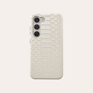 May include: A white phone case with a snakeskin pattern.