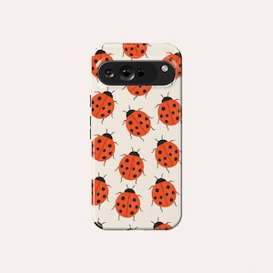 Op de afbeelding: Een witte telefoonhoes met een patroon van rode lieveheersbeestjes met zwarte stippen. De hoes heeft een zwarte camera lens.