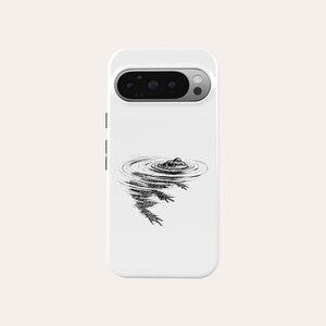 May include: White phone case featuring a black and white illustration of a frog in water. The frog's eyes and the ripples in the water are the focal point of the design. The case has a camera cutout.