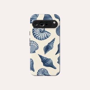 May include: A white phone case with a blue and white seashell pattern. The case has a camera lens cutout and a white background.