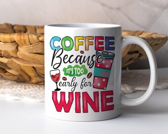 May include: White ceramic coffee mug with a colorful design that says "Coffee because it's too early for wine". The design includes a coffee cup, a wine glass, and coffee beans.
