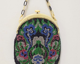 May include: A vintage beaded purse with a floral design in shades of blue, green, pink, and silver. The purse has a cream-colored frame and a black chain strap.