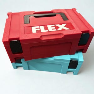 Puede incluir: Un malet&iacute;n de herramientas de pl&aacute;stico rojo con asa negra y la palabra FLEX impresa en letras blancas en la parte superior, apilado sobre un malet&iacute;n de herramientas de pl&aacute;stico azul claro del mismo dise&ntilde;o, con detalles negros en las esquinas.