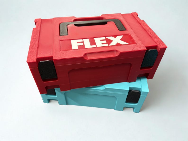 Puede incluir: Un malet&iacute;n de herramientas de pl&aacute;stico rojo con asa negra y la palabra FLEX impresa en letras blancas en la parte superior, apilado sobre un malet&iacute;n de herramientas de pl&aacute;stico azul claro del mismo dise&ntilde;o, con detalles negros en las esquinas.