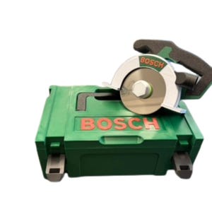 Puede incluir: Un malet&iacute;n de transporte de pl&aacute;stico verde de Bosch con una sierra circular verde y plateada encima. La sierra cuenta con un mango negro, un protector de hoja plateado y el logotipo de Bosch en letras rojas tanto en la herramienta como en la caja.