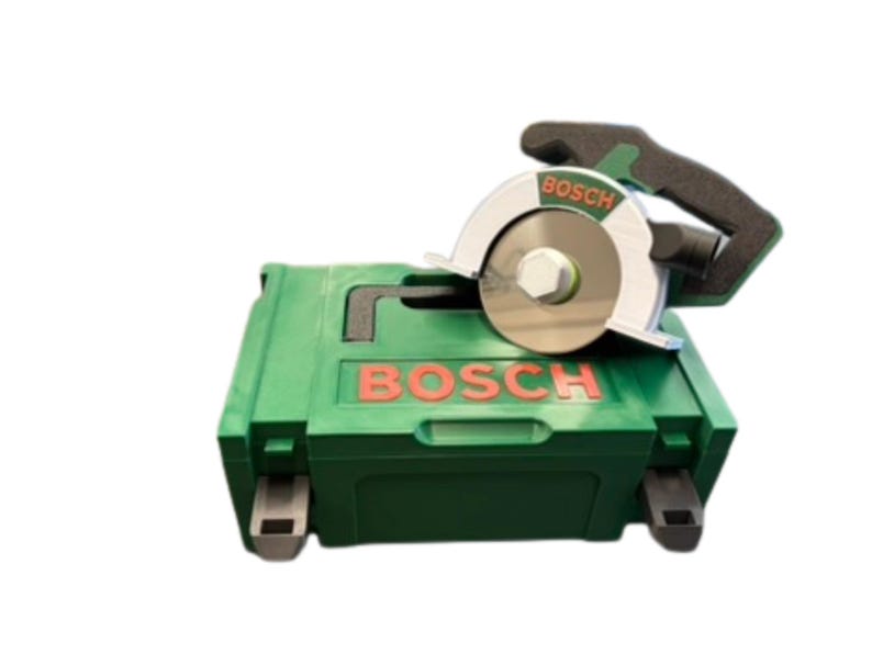 Puede incluir: Un malet&iacute;n de transporte de pl&aacute;stico verde de Bosch con una sierra circular verde y plateada encima. La sierra cuenta con un mango negro, un protector de hoja plateado y el logotipo de Bosch en letras rojas tanto en la herramienta como en la caja.