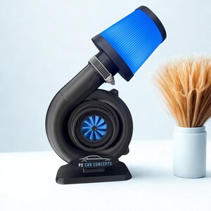 Könnte beinhalten: Ein schwarzes Turbolader-Modell mit einem leuchtend blauen Ansauglüfter und einem passenden blauen konischen Luftfilter, der mit einer Metallschelle befestigt ist. Die Basis zeigt den Text PS CAR CONCEPTS mit einer einfachen Strichzeichnung eines Autos.