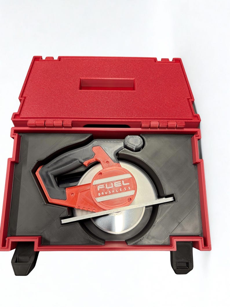 Puede incluir: Una sierra circular roja y negra con la etiqueta FUEL BRUSHLESS en el lateral, colocada dentro de un inserto negro a medida en un malet&iacute;n de transporte de pl&aacute;stico rojo. La sierra cuenta con una hoja met&aacute;lica y un mango integrado.