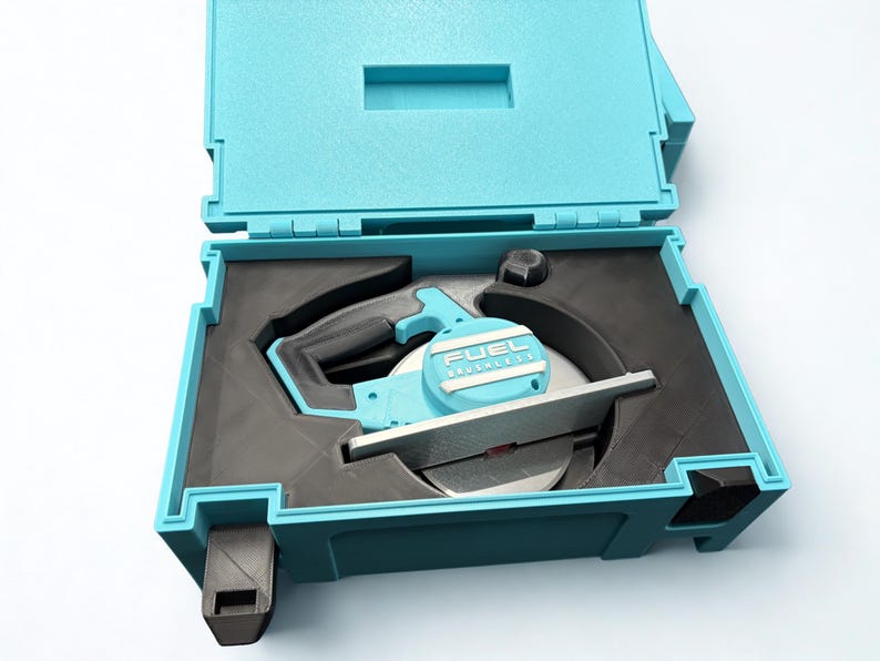 Puede incluir: Una sierra circular de color azul claro con hoja plateada y mango negro, que presenta el texto FUEL BRUSHLESS en la carcasa del motor. La herramienta se guarda en un inserto de espuma negra a medida dentro de un malet&iacute;n de pl&aacute;stico.