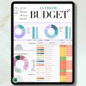 May include: A digital tablet displays a budget spreadsheet with charts and tables. The title "ULTIMATE BUDGET" is at the top. The spreadsheet includes sections for income, expenses, and breakdowns, with various categories and amounts. The interface includes a paste, cut, copy, and format option.