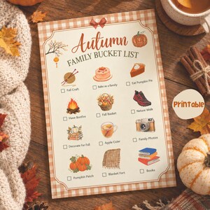 Könnte beinhalten: Eine herbstliche Familien-Bucket-List als druckbare Checkliste mit beigem Karomuster-Rand. Die Liste enthält Illustrationen von Kürbis, Kuchen, Lagerfeuer, Kamera und Büchern sowie Kästchen zum Abhaken der verschiedenen Aktivitäten.