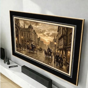 Puede incluir: Obra de arte enmarcada que representa una escena de calle europea vintage con carruajes tirados por caballos, calles empedradas y farolas de gas. La obra está enmarcada en negro con un borde interior dorado y está montada en una pared blanca. La paleta de colores es cálida, con tonos sepia.