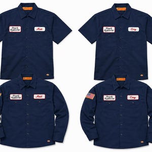 May include: Four navy blue work shirts are shown. Two are short-sleeved, and two are long-sleeved. Each shirt has a name patch and a "Bicycle Accident Club" patch. One long-sleeved shirt has an American flag patch.