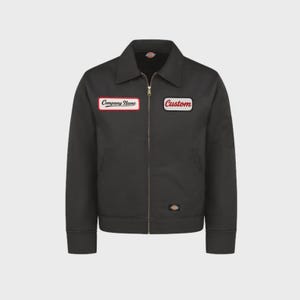 Könnte beinhalten: Schwarze Arbeitsjacke mit Reißverschluss, Kragen und zwei rechteckigen Aufnähern. Einer zeigt "Company Name" in weißer Schrift auf rotem Rand, der andere "Custom" in weiß auf rotem Rand. Eine kleine Tasche befindet sich am linken Ärmel.