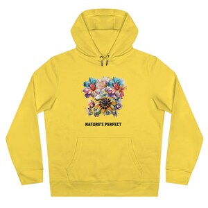 Peut inclure: Sweat-shirt à capuche jaune avec un motif floral coloré et le texte "NATURE'S PERFECT" imprimé sur le devant.