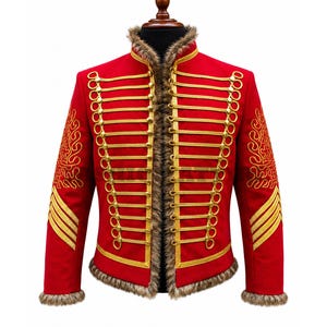 May include: A bright red military-style jacket featuring gold braided cord detailing, metallic buttons, and brown faux fur trim along the collar, front opening, and cuffs. The sleeves are decorated with gold embroidered patterns.