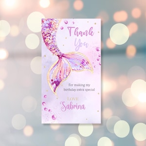 Può includere: Biglietto di ringraziamento con coda di sirena viola e dorata con il testo "Grazie" e "Per aver reso il mio compleanno ancora più speciale. Con affetto, Sabrina."