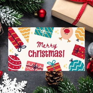 May include: A Christmas card with the words "Merry Christmas!" surrounded by illustrations of gifts, baubles, and a reindeer. The card is decorated with pine needles, a pine cone, and Christmas decorations.