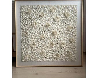 May include: A square framed wall art piece featuring a white textured design of many small, raised, flower-like shapes.