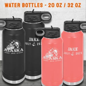 K&ouml;nnte beinhalten: Vier isolierte Wasserflaschen mit schwarzem und korallenrosa Finish. Jede Flasche hat einen schwarzen Deckel mit einem Klappverschluss. Die Flaschen zeigen wei&szlig;en gravierten Text und Grafiken, darunter "ALASKA" und "JAKE JULY 2021" oder "2025".