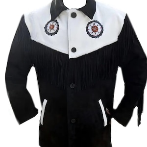 Könnte beinhalten: Schwarz-weiße Wildlederjacke mit Fransen. Die Jacke hat einen weißen Einsatz mit zwei gestickten kreisförmigen Designs und schwarzen Knöpfen. Die Ärmel und der Körper sind schwarz, mit weißen Akzenten auf den Taschen.