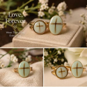 May include: Gold rings with a cross design. The rings have a light green oval or round center with a brown cross. The text "Love, Forever" and "Wear Their Love Every Day" is visible in the image.