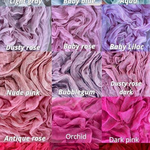 May include: A collection of 12 fabric swatches in various shades of blue, pink, and red. The swatches are made of a soft, gauzy material and are arranged in a grid pattern. The colours are labelled with their names, such as "Light Gray", "Baby Blue", "Aqua", "Dusty Rose", "Baby Rose", "Baby Lilac", "Nude Pink", "Bubblegum", "Dusty Rose Dark", "Antique Rose", "Orchid", "Dark Pink", "Red", "Marsala", and "Maroon".
