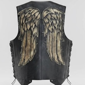 Puede incluir: Chaleco de cuero negro con un diseño detallado de alas de ángel en la espalda. Las alas son una combinación de beige y blanco, con intrincados detalles de plumas. El chaleco tiene un cierre de cordones en los laterales.