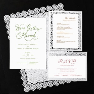May include: Elegant wedding invitation suite with a white lace border. The main card reads "We're Getting Married" in green script, with details of the ceremony, reception, and RSVP information. The suite is set against a black background.