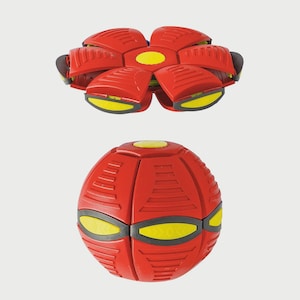 Può includere: Un giocattolo volante a forma di disco rosso e giallo che si piega in una forma sferica. Il disco ha un design a forma di fiore con sei petali e un centro giallo. La forma sferica ha una superficie testurizzata e tre occhi gialli.