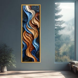 Puede incluir: Arte mural abstracto en un marco dorado rectangular vertical. La obra presenta formas fluidas y superpuestas en tonos de azul, marrón y beige. El diseño tiene una apariencia texturizada, creando una sensación de profundidad y movimiento. La obra se exhibe en una pared azul oscuro.