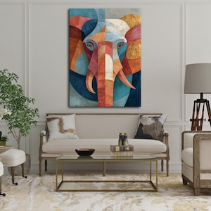 May include: Geometric elephant art print. The artwork features a stylized elephant head with a colorful mosaic design. The color palette includes shades of blue, orange, red, and gold. The artwork is displayed on a wall in a living room setting.