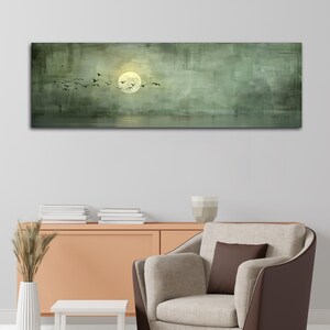 Puede incluir: Una impresi&oacute;n rectangular en lienzo representa un paisaje sereno. Una luna llena brilla intensamente, con p&aacute;jaros silueteados en vuelo. El fondo es verde apagado con textura sutil, sugiriendo una escena tranquila sobre el agua.