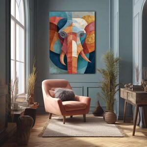 May include: A large, colorful geometric elephant art print hangs on a teal wall above a peach armchair. The artwork features a stylized elephant face with orange, red, blue, and gold shapes. The room has a rug, a wooden desk, and a window.