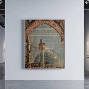 May include: An art gallery interior featuring a framed painting of a mosque with a blue dome and minaret. The painting is framed with a decorative archway. The gallery has white walls and a polished concrete floor.